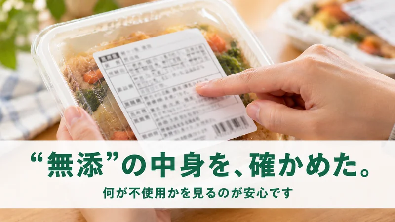 惣菜パックの原材料ラベルを指で確かめる手元。何が不使用かを見るのが安心