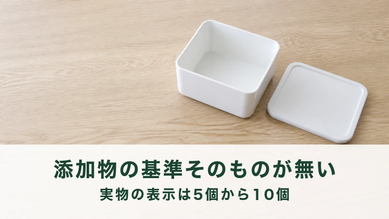 木の机に空の白い保存容器とふたが横に外してある