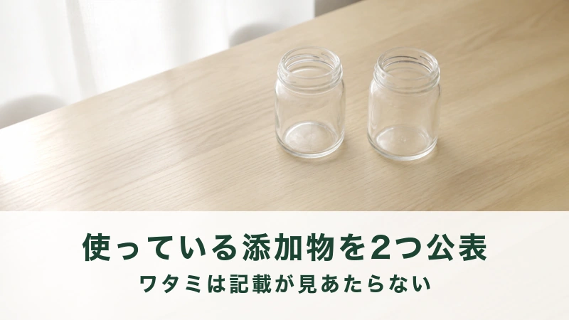 明るい木の机にふたを開けた空のガラスびんが二本