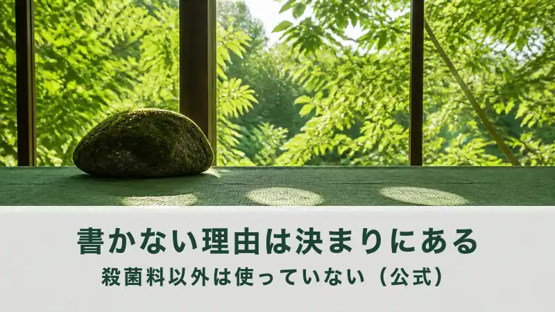 新緑の窓辺の緑の板に苔むした石が一つのる