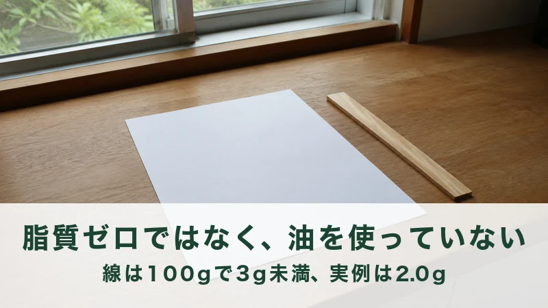 窓辺の木の台に広げた一枚の白い紙と細いものさし