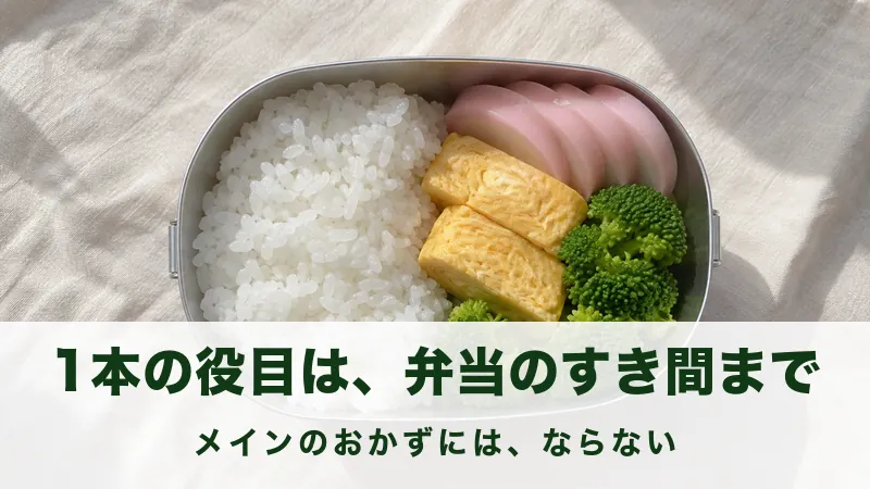 弁当箱にごはんと輪切りの練り物と卵焼きを詰めた俯瞰