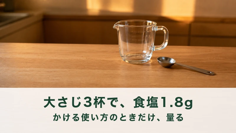 夕方の食卓に小鉢の酢の物と計量スプーンが置かれている