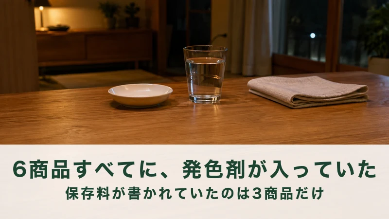 夜のリビングの木のテーブルに白い小皿と水のグラス、たたんだ布