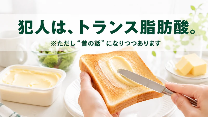 朝の食卓でトーストにマーガリンを塗る手元。犯人は、トランス脂肪酸。ただし昔の話になりつつあります