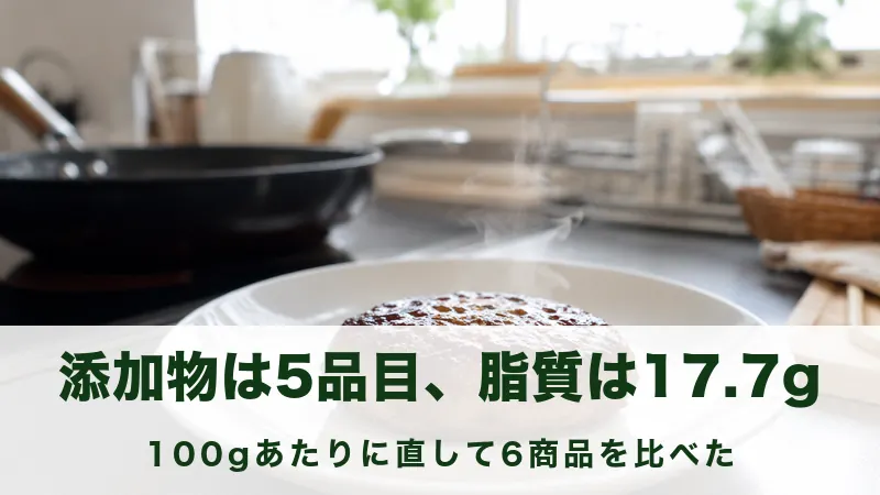 白い皿にのせた焼きたてのハンバーグと湯気の立つ台所