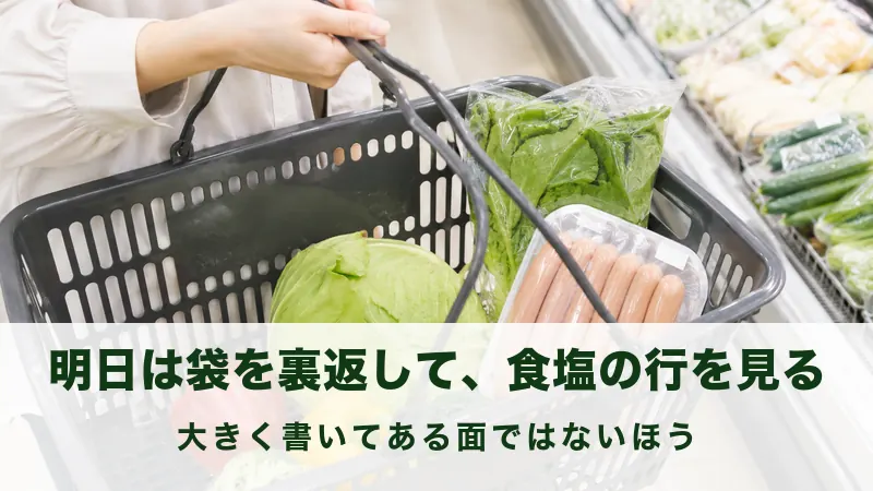 買い物かごに無地のソーセージのパックと野菜が入る場面