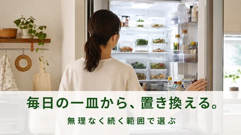 作り置きの容器が並んだ冷蔵庫を開けて眺める女性