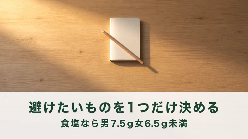 夕方の光がさす机に交差して置かれたメモ帳と鉛筆