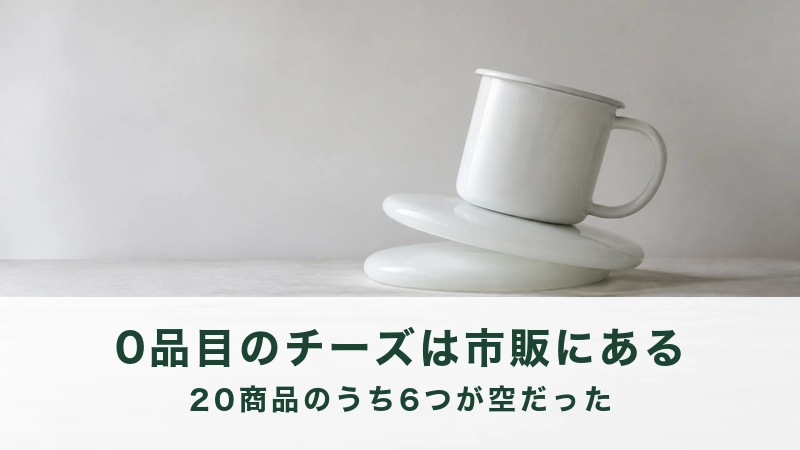 灰色の壁の前で、重ねた白い丸皿の上に白いホーローのマグカップがのっている
