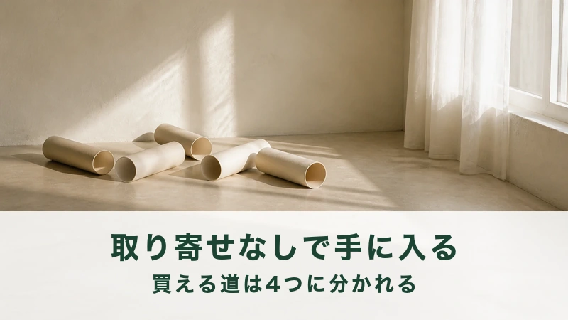 窓の光が入る部屋にクリーム色の筒が散らばる