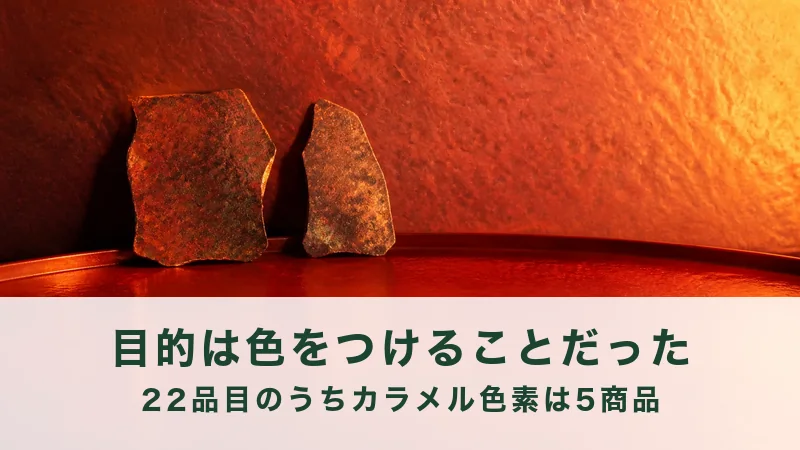朱色の壁ぎわに、さびた銅の板きれが2枚立つ