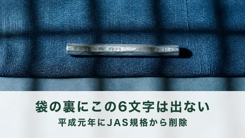 紺の布の折り目に細い金物が1本のる