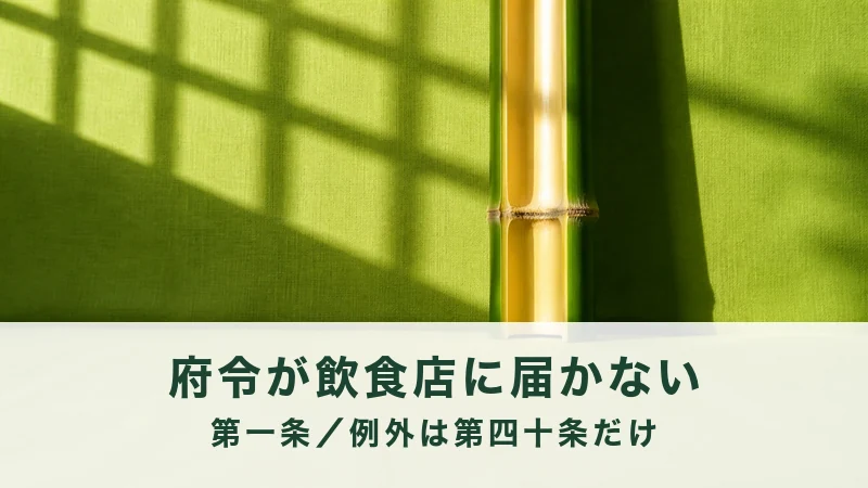 格子の影が落ちる緑の壁に竹が1本立つ