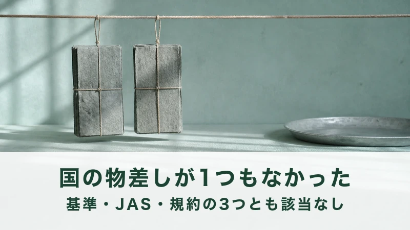 灰色の板が2枚、麻紐に吊るされて揺れている