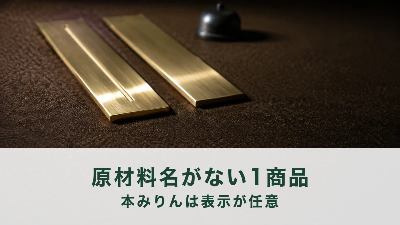 焦茶の革の台に真鍮の細長い板が二枚並び、左の一枚だけに細い筋が入る