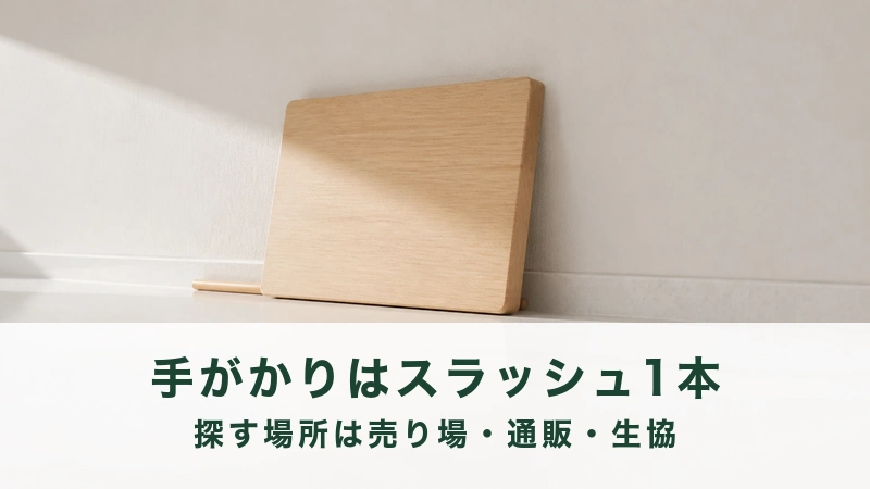 白い壁に木の板が一枚立てかけてある