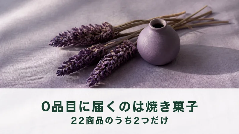 薄紫の布の上に、乾いた紫の花穂が三本と藤色の炻器の一輪挿しが一本ある