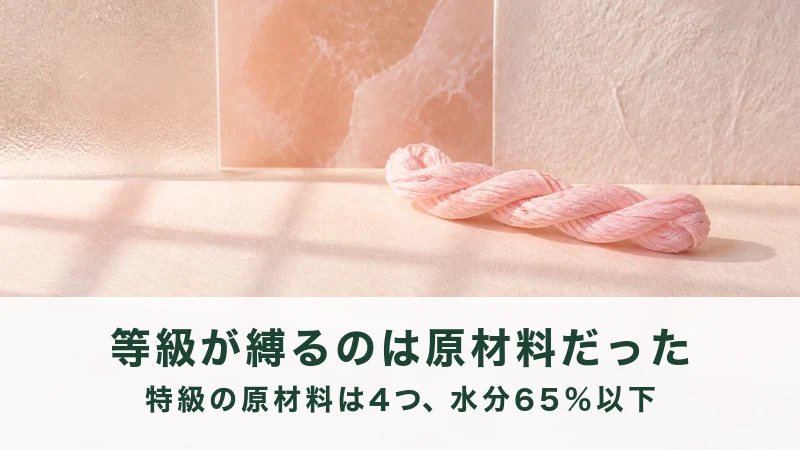 淡い桃色のより糸が1束、明るい台に置かれる