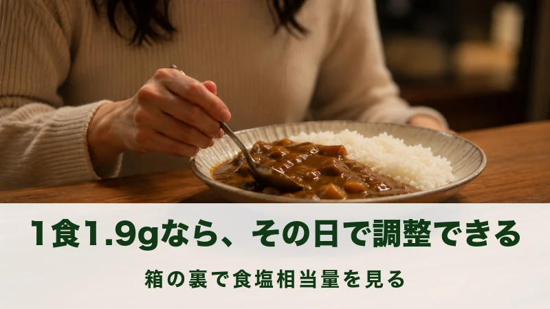 夕方の食卓でスプーンを持ってカレーの皿に向かう手元