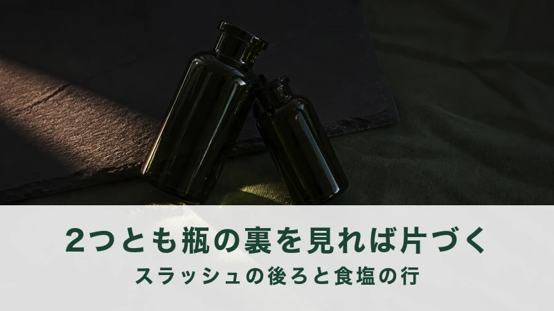 暗い布の上に緑のガラス瓶が2本倒れている