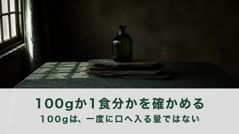 窓のある暗い部屋で石の板に緑の瓶をのせた