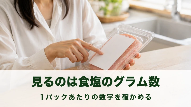 透明なパックを裏返して白いラベルを指でたどる手元