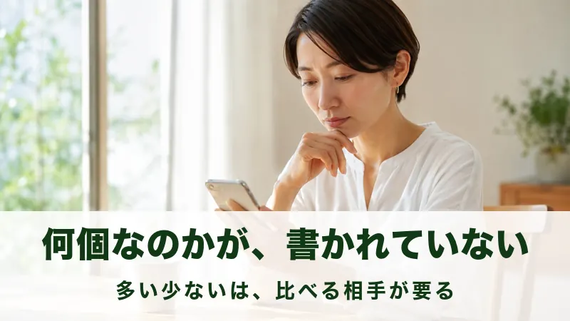 テーブルでスマートフォンの画面を見て考えこむ女性の情景