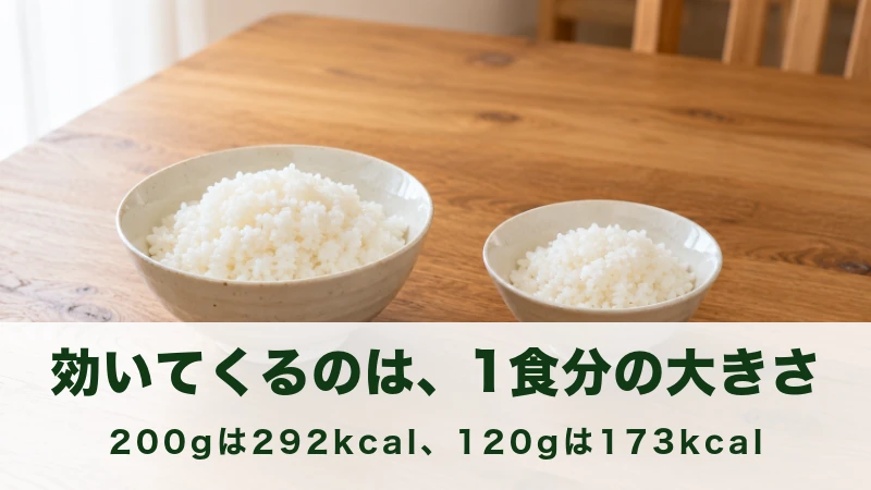 木のテーブルに大小2つの茶碗のごはんが並ぶ