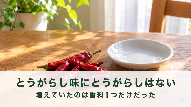 朝の光が差す木のテーブルに赤いとうがらしと白い小皿