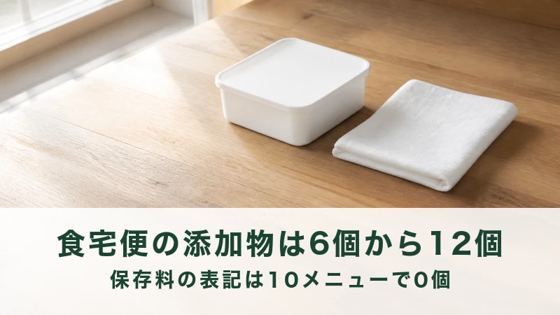 木のテーブルに置かれた白い保存容器と白い布巾
