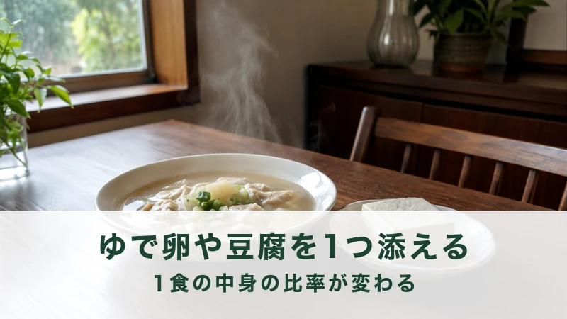 木の食卓に並ぶ湯気の立つスープ皿と小皿にのせた豆腐