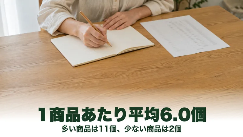 木のテーブルでノートに鉛筆で数字を書いている手元