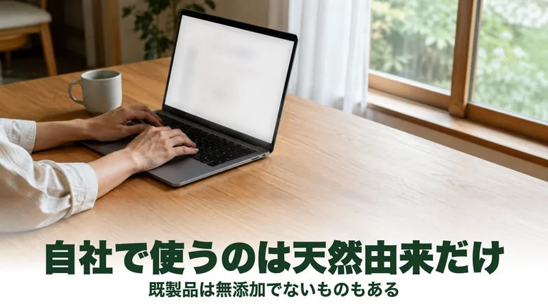 窓辺のテーブルでノートパソコンの画面を読む人の手元