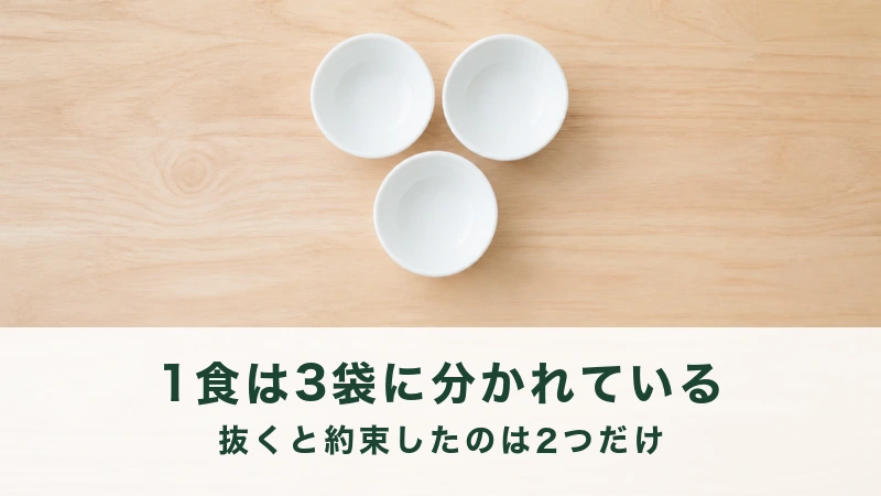 木のテーブルに三角に並べた空の白い小鉢三つ
