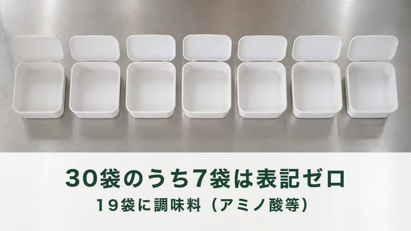 調理台に横一列で並ぶふたのない空の容器七つ