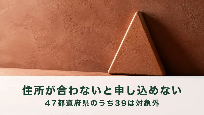 素焼き色の壁ぎわに、三角の板が一枚立てかけてある