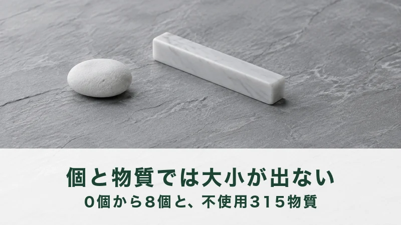 灰色の石の台に、丸い白い石と細長い白い大理石の棒が離して置かれている