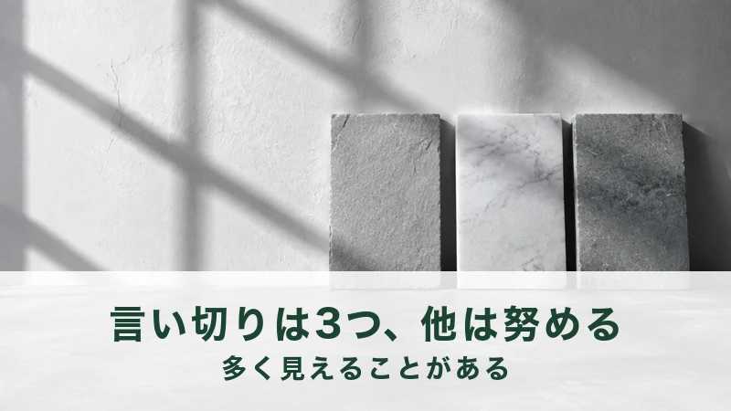 白い壁に窓の影が落ち、その前に灰色と白の石板が3枚立てかけてある