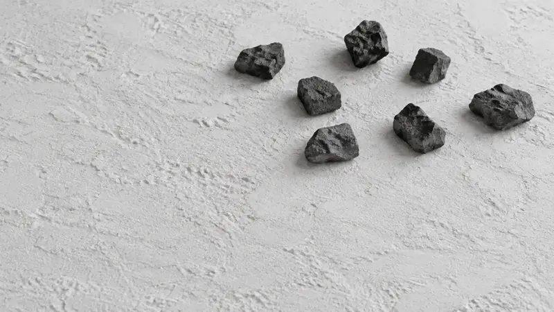 白いざらついた面に、黒っぽい小石を七つ散らして置いた