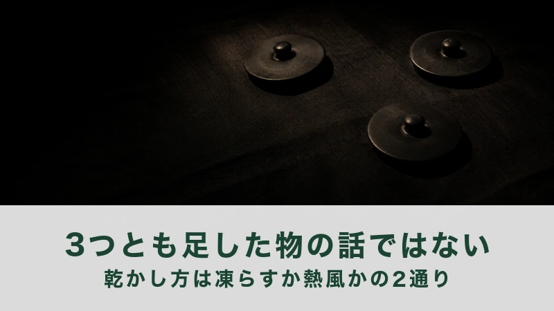 暗い布の上に、つまみの付いた黒い陶器の蓋を3枚、離して置いた