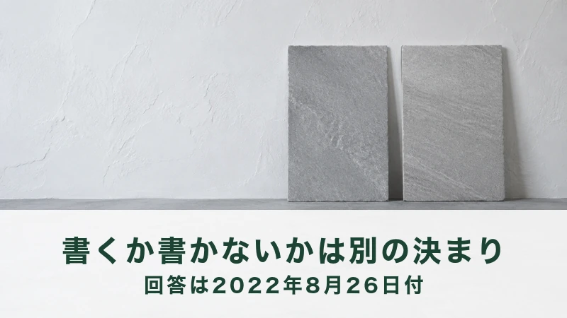 白い壁ぎわの台に、細長い灰色の石板が2枚立てかけてある