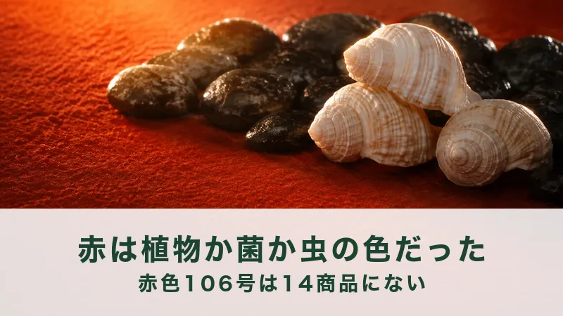 朱色の布に黒く光る小石を寄せ、白い巻き貝を3つ、夕日の色で並べた