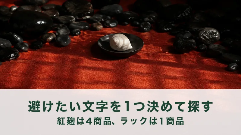 赤い布に黒い石を並べ、真ん中の黒い小皿に白い巻き貝を1つだけ載せた