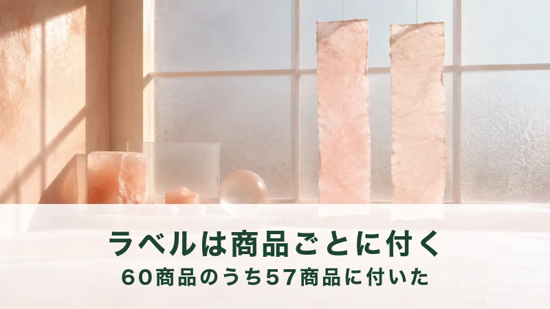 すりガラスの窓辺に細長い桃色の紙が二枚下がり、下に桃色の石と丸いガラス玉