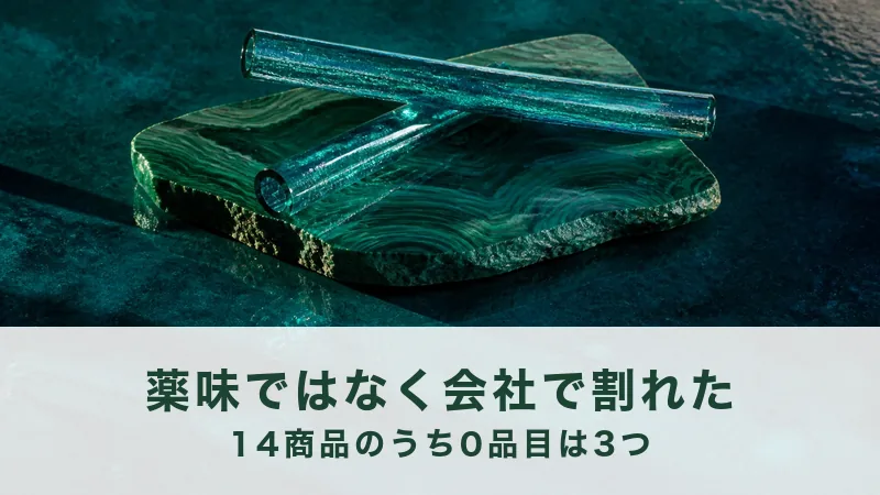 孔雀石の板の上に青緑のガラスの細い筒が二本、崩れた積み方で重なっている