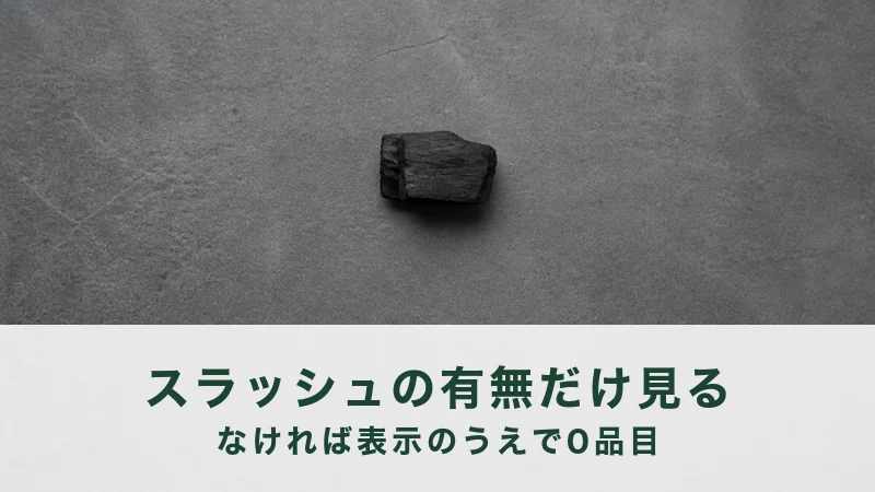 灰色の石の平らな面の中央に割った木炭の塊が一個だけ小さく置いてある