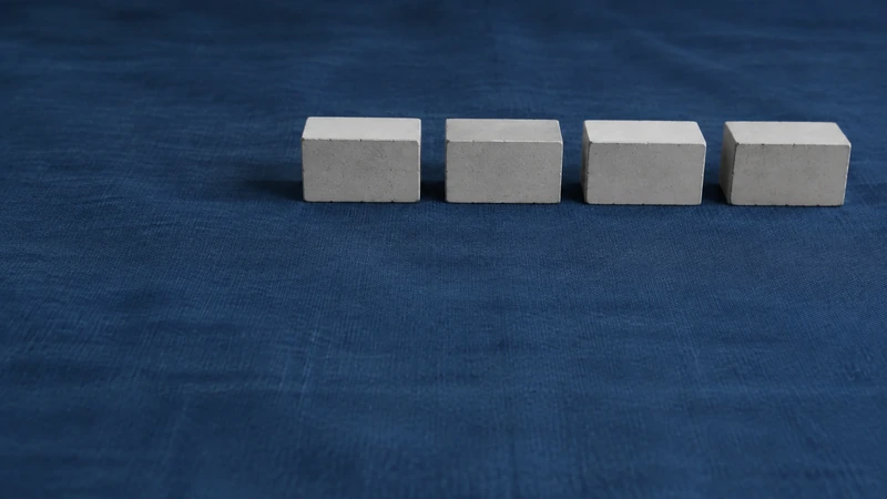 濃紺の布の面に白い小さな直方体が四つ横に並ぶ