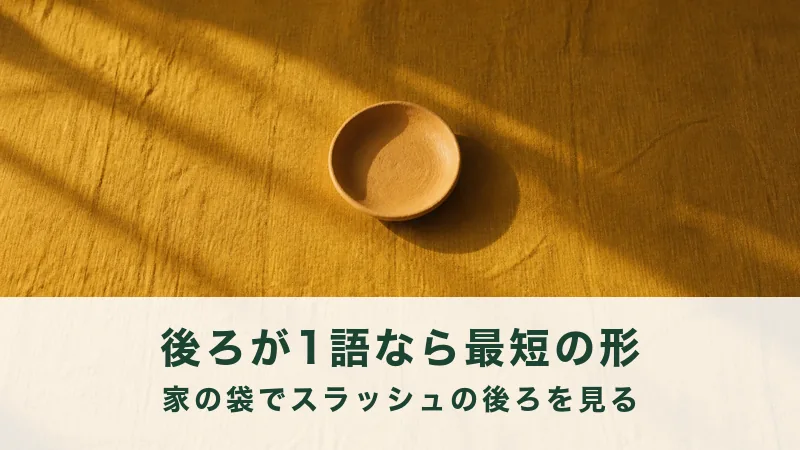 からし色の布に空の素焼きの浅皿が一つ。後ろが一語かを見る結び