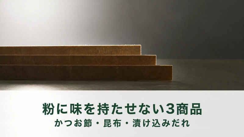 逆光の台にクラフト紙の細長い帯が三枚ずれて重なっている。うま味の置き場所を移す話